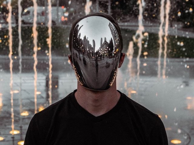 Figure in mirror mask — synthetic media essay hero